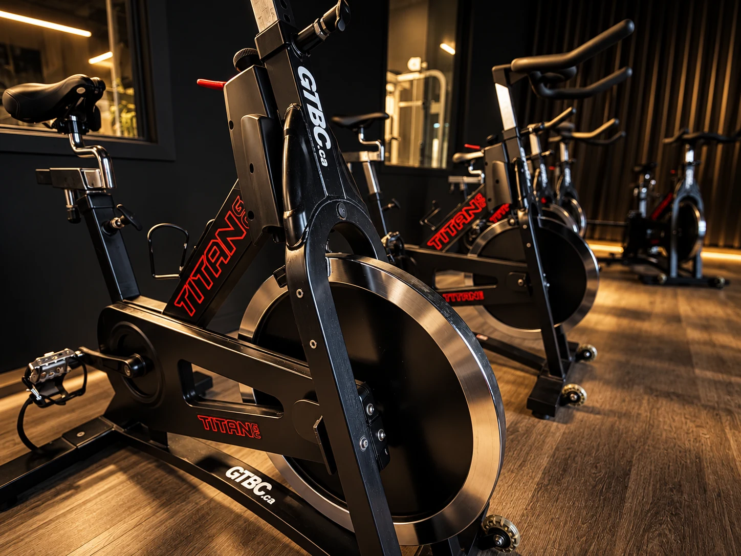 Indoor cycling bikes on the wood floor of the NRG spin studio.